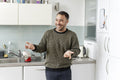 Smiling mature man standing in kitchen at home