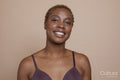 Studio portrait of smiling woman wearing bra