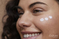 Close-up of young woman applying face cream