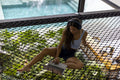 Woman relaxing on netting and using laptop with headphones