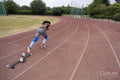 Rear view of athletic woman running on track