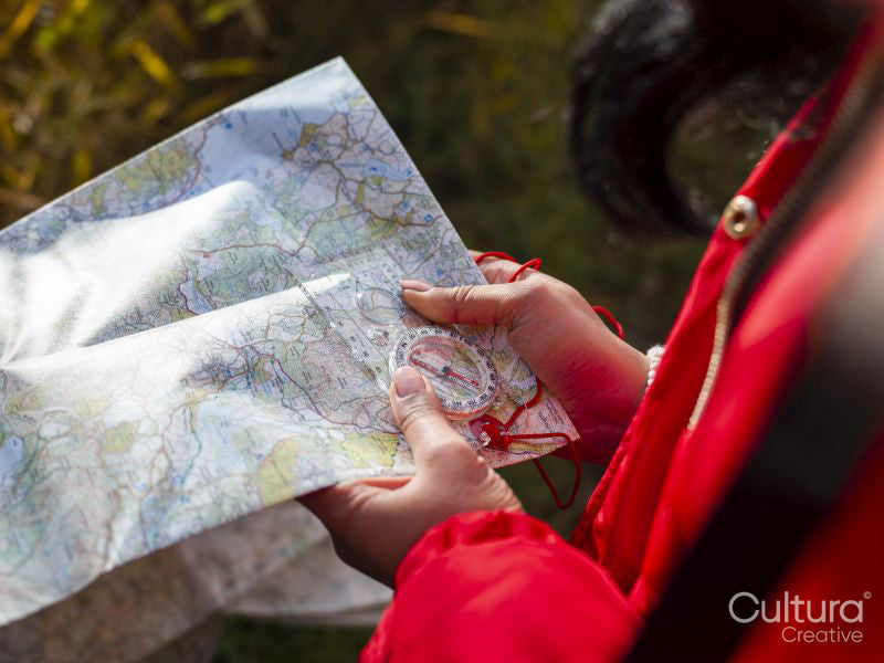 Female hiker using map and compass