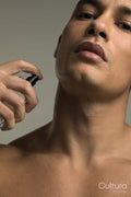 Close-up of man spraying perfume on neck