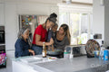 Family of females preparing meal in kitchen