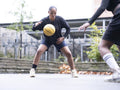 Two female friends playing basketball outdoors