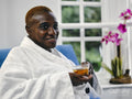 Mature woman in white bathrobe enjoying tea