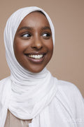 Studio shot of smiling young woman wearing white hijab