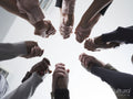 People stacking hands in circle in group therapy session
