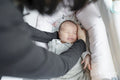 Mother putting baby daughter in baby crib