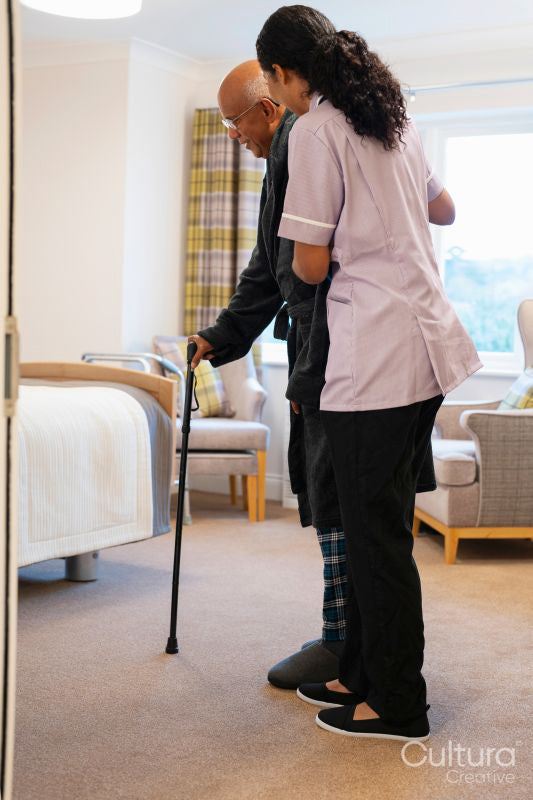 Nurse helping senior man in his room at nursing home