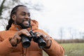 Man looking through binoculars in rural area