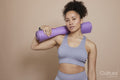 Studio portrait of athletic woman with yoga mat