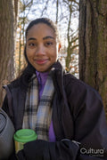 Portrait of young woman holding cup and yoga mat