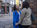 Smiling couple holding hands in city