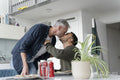 Male couple kissing and eating breakfast at home
