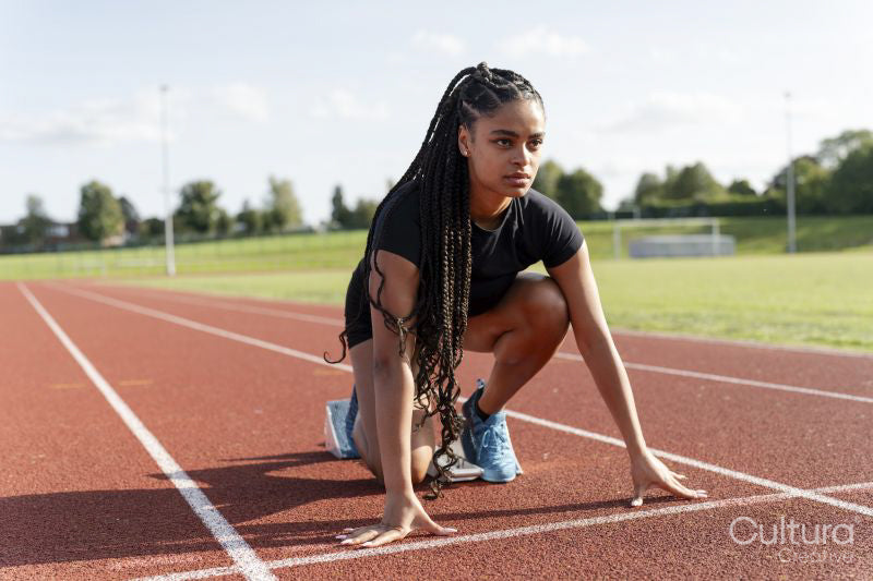 Female athlete preparing to run at stadium