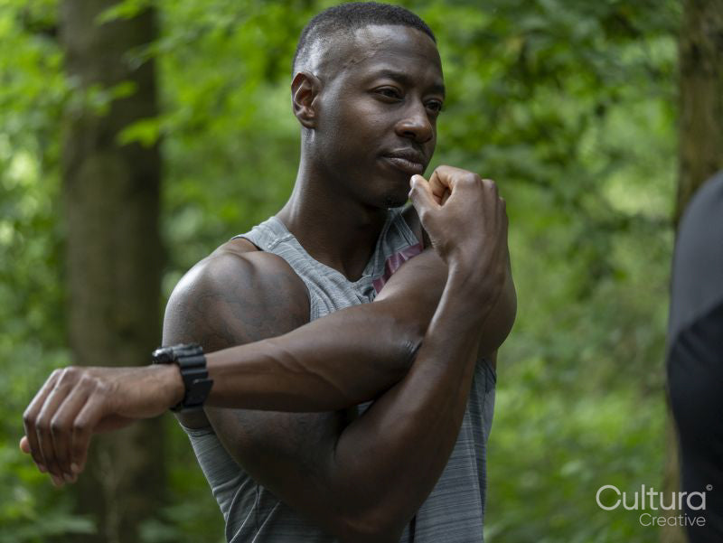 Man stretching after workout in forest