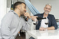 Male couple pouring red wine at home