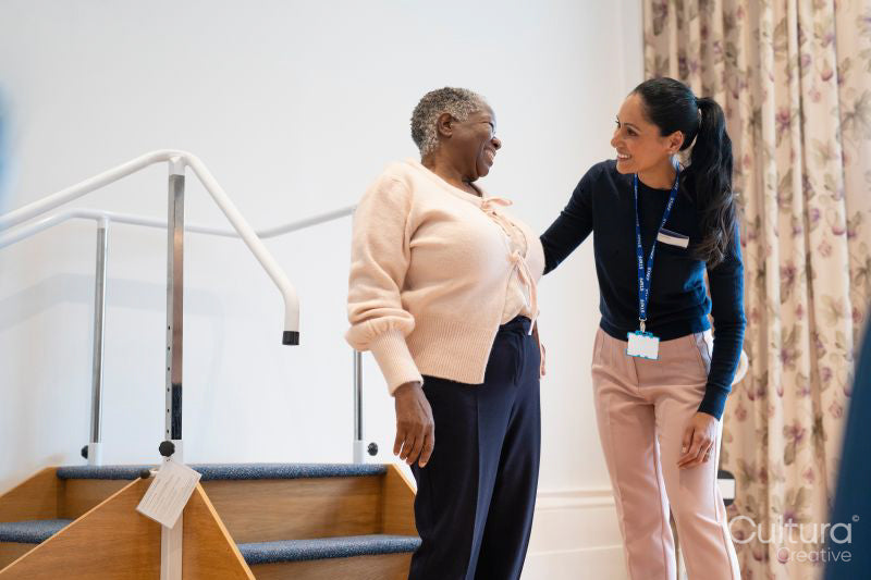 Smiling female therapist and senior woman talking in exercise room