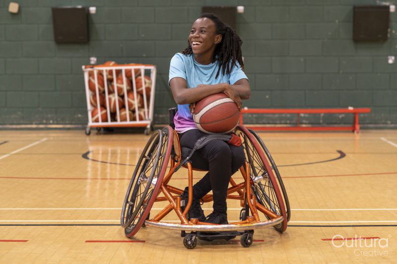 Teenage girl in wheelchair on basketball court