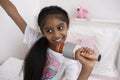 Smiling girl with microphone on bed