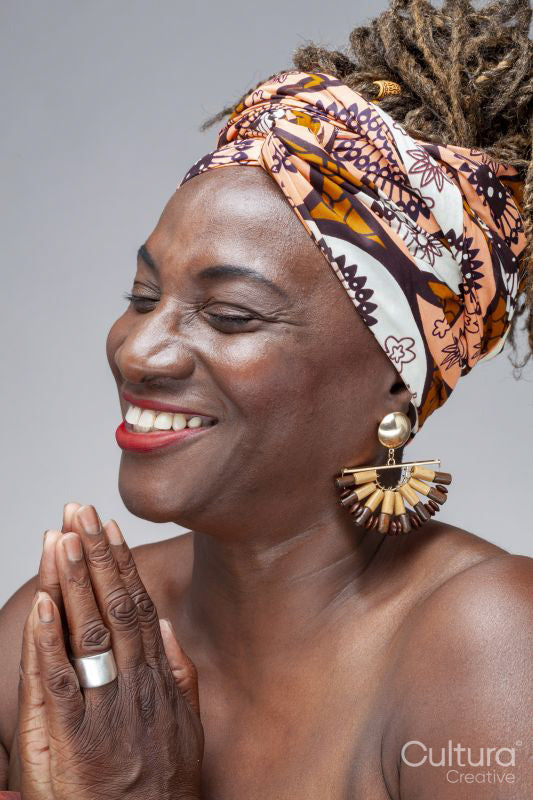 Studio shot of smiling mature woman in headscarf