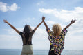 Female couple holding hands on beach