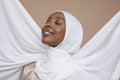 Studio shot of smiling young woman in white hijab