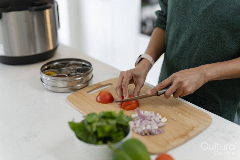 Woman cutting tomatoes on cutting board