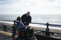 Father and disabled son by the sea
