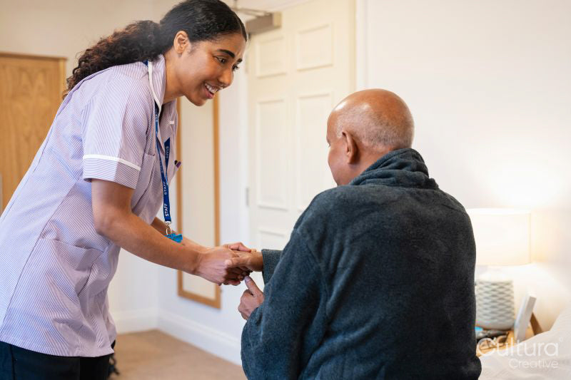 Nurse visiting senior man in his room at nursing home
