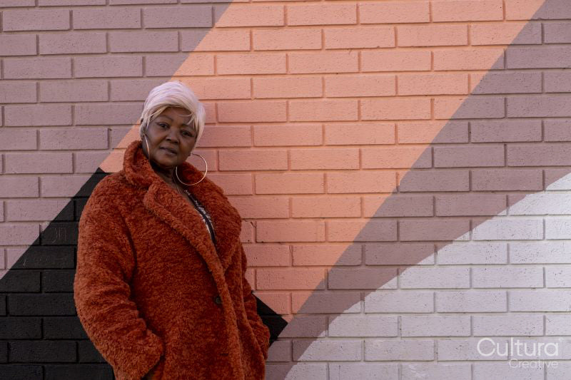 South Yorkshire, Portrait of stylish woman in fake fur coat standing by wall
