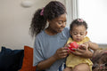 Mother playing with baby daughter at home