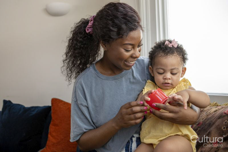 Mother playing with baby daughter at home