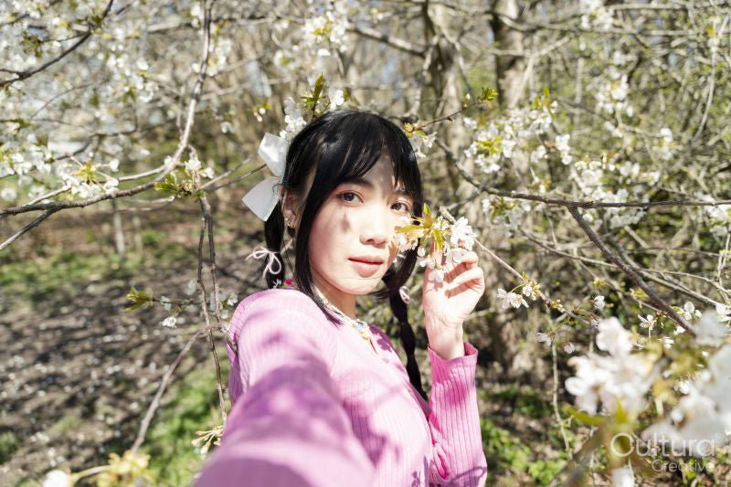 Portrait of young woman among tree blossom