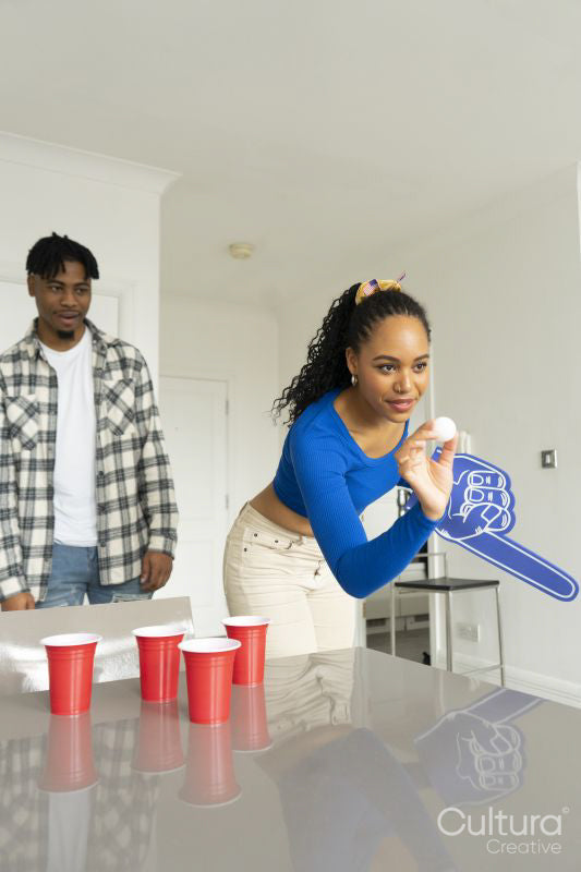 Friends playing beer pong at home party
