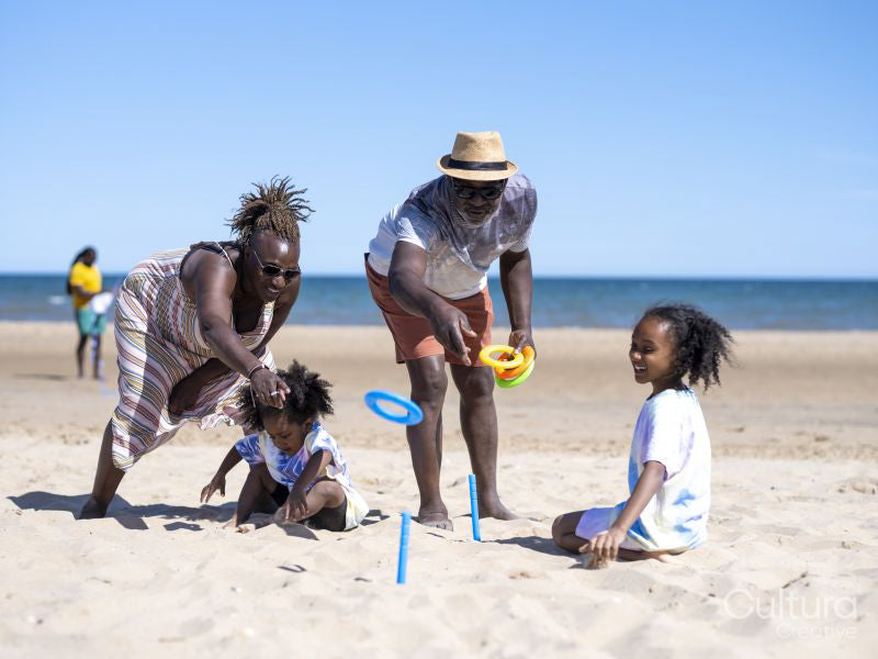 Family with children playing ring toss on beach
