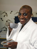 Portrait of mature woman in bathrobe drinking coffee in hotel room