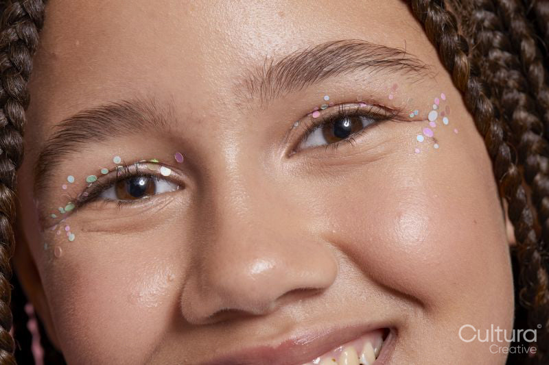 Close-up of smiling girl with decorative stickers on face