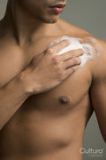 Close-up of man applying soap on chest