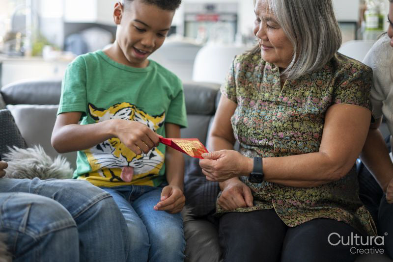 Family gathered in living room, sharing red envelopes