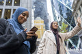 Two women wearing hijabs standing in street