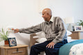 Senior man pushing call button in his room at nursing home