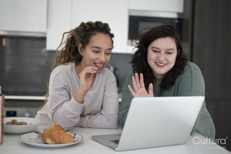 Two women looking at laptop in kitchen