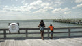 Rear view of brother and sister standing on pier