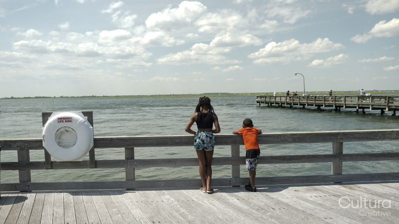 Rear view of brother and sister standing on pier
