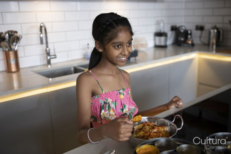 Smiling girl cooking in kitchen