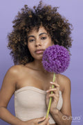 Portrait of brunette woman holding purple flower
