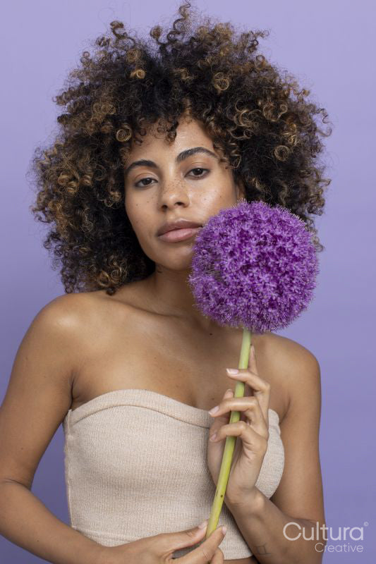 Portrait of brunette woman holding purple flower