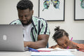 Father using laptop and daughter drawing in notepad